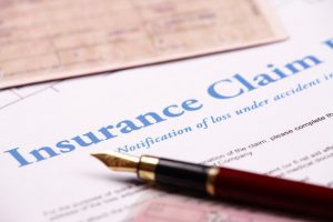 Close-up of fountain pen laying on insurance claim form insurance lawyer in orlando