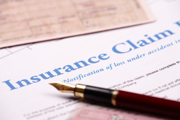 Close-up of fountain pen laying on insurance claim form insurance lawyer in orlando
