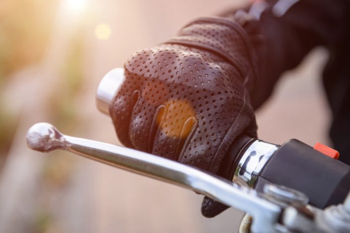 protective biker gloves on a motorcycle wheel uninsured motorist coverage